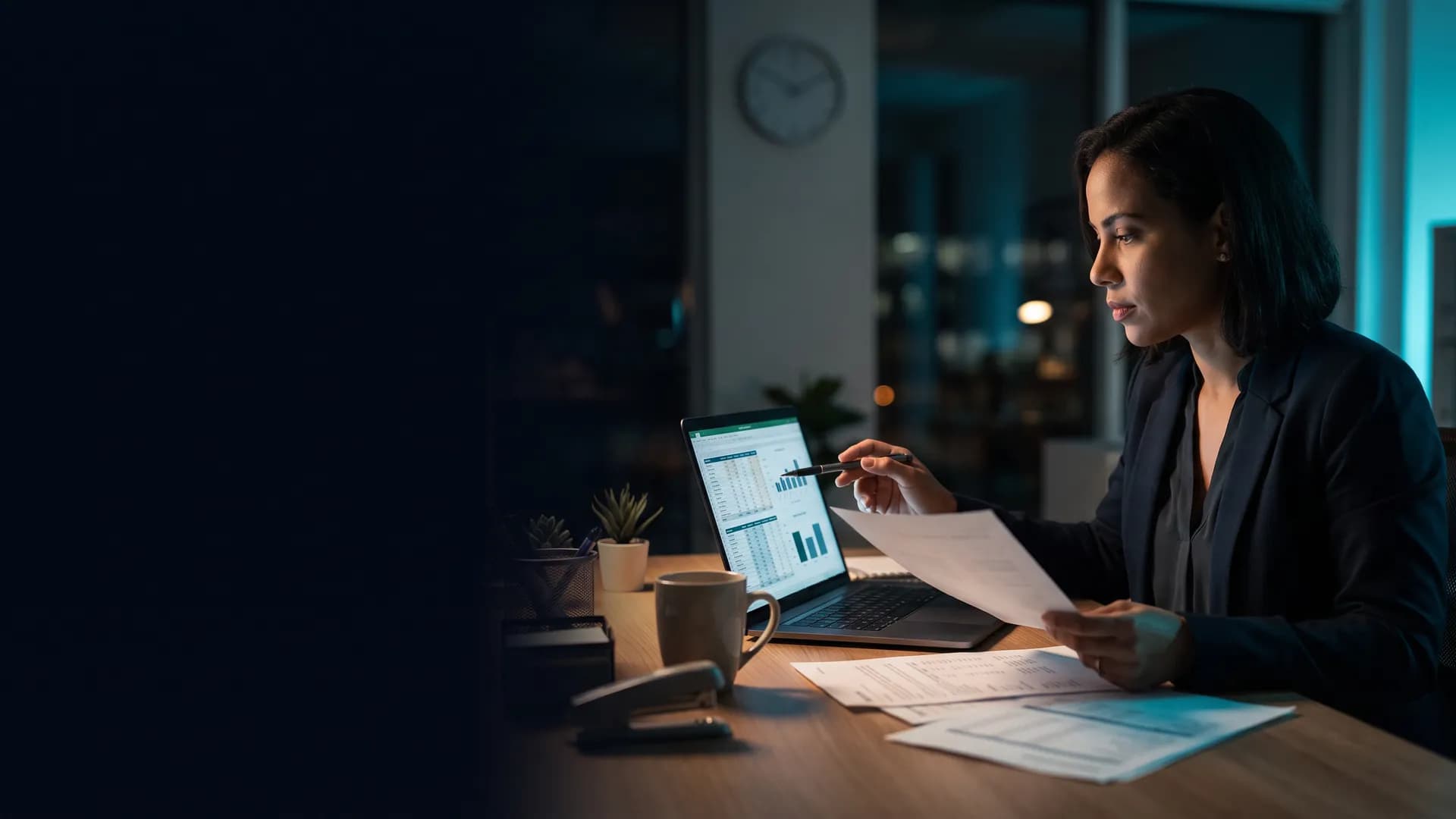 Auxiliar de compras comparando cotações no laptop e em papéis na mesa